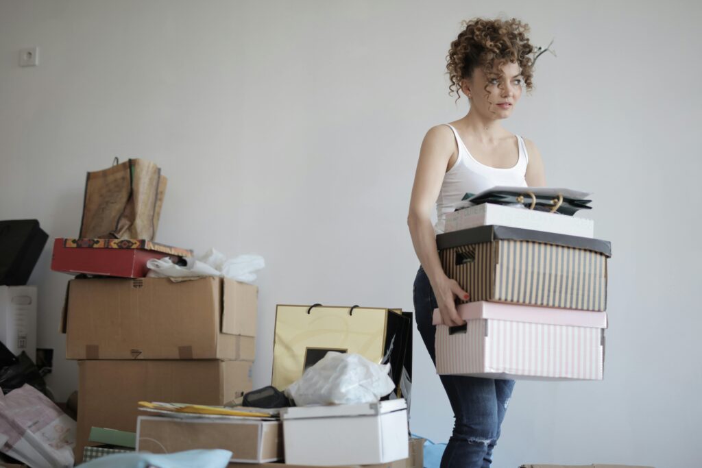 Concentrated woman carrying stack of cardboard boxes for junk removal miami florida