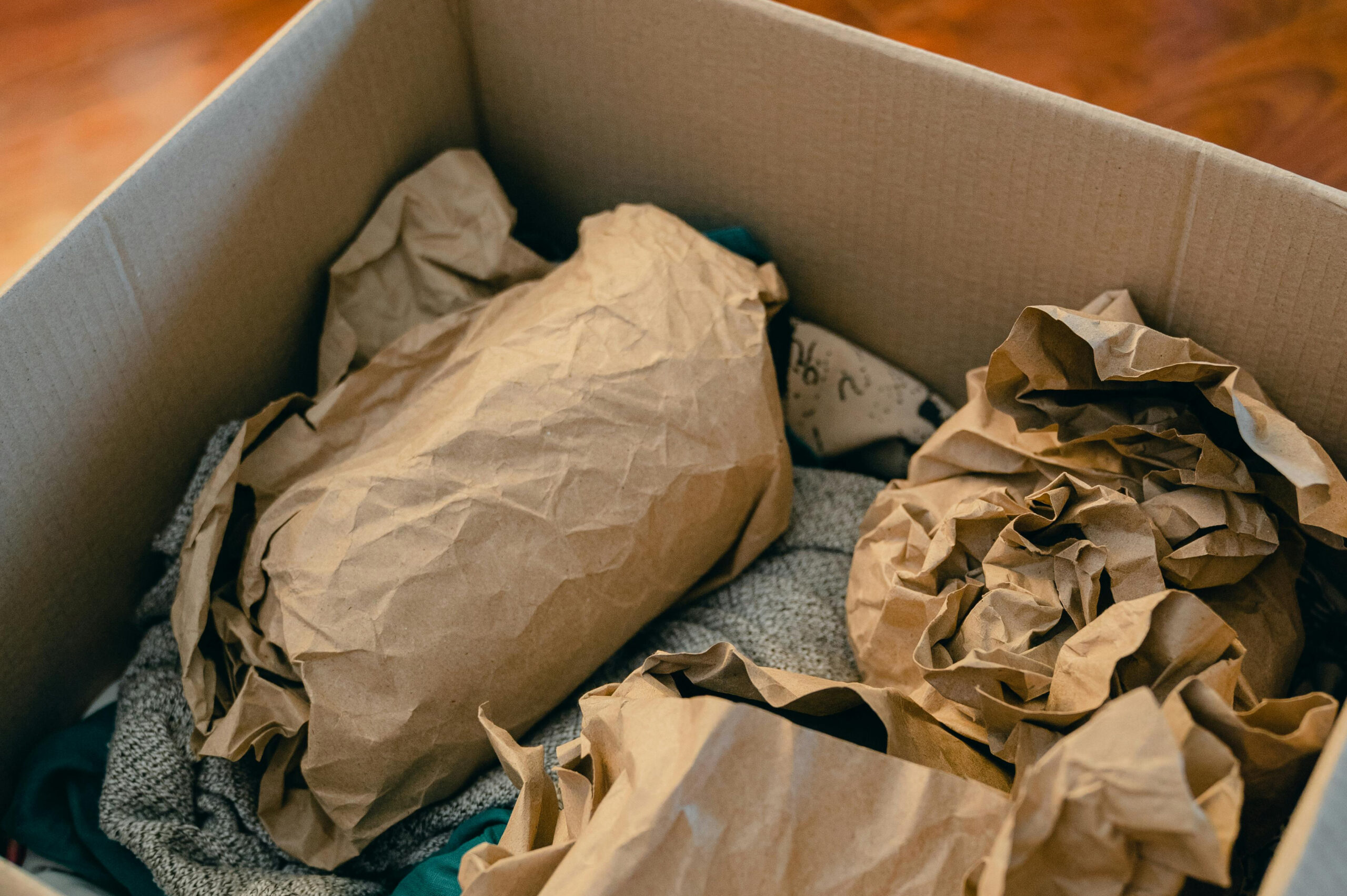 Box with objects wrapped in brown paper for moving